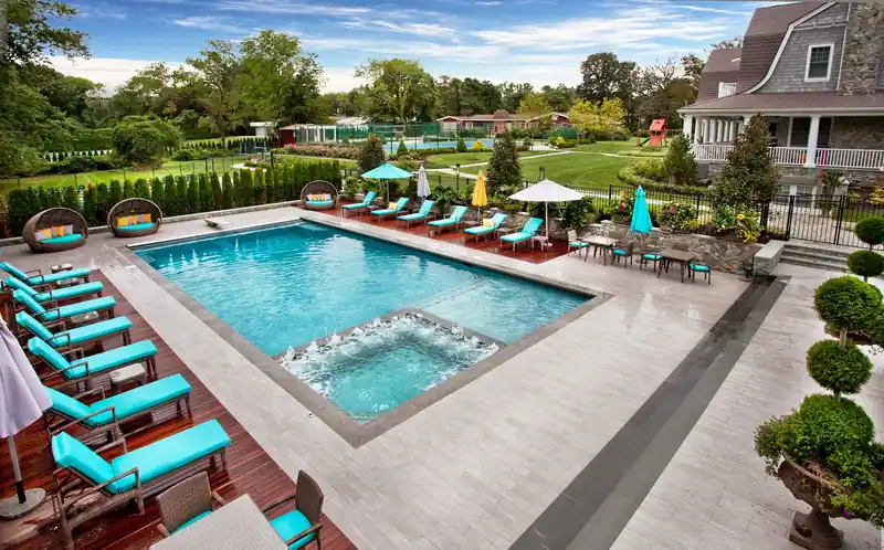 Pool edged with teal loungers and clipped topiary