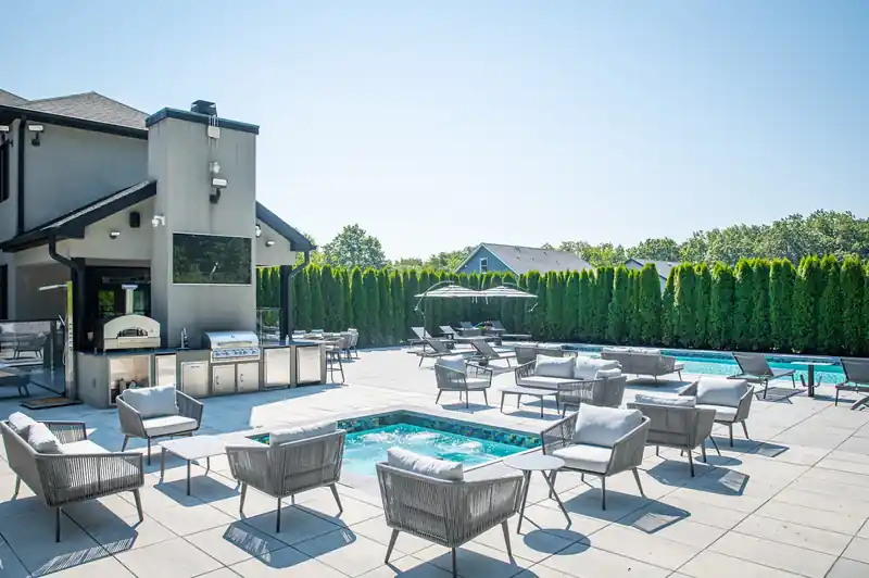 Covered outdoor kitchen and lounge terrace beside a pool