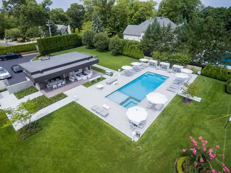 Pool with a white deck and a pavilion at the far end