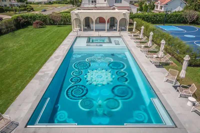 Rectangular pool with an ornate mosaic floor, a white pavilion at the far end