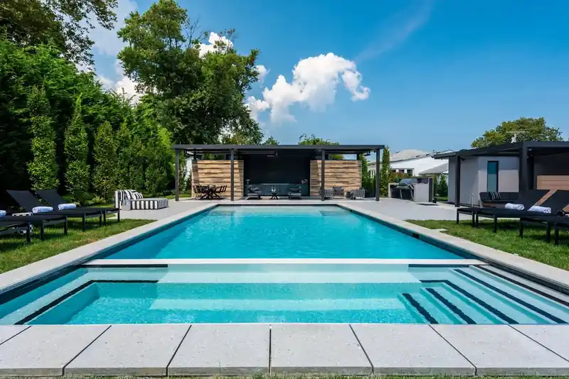 Full-width entry steps across a pool, a dark pavilion behind