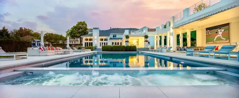 Wide view of a pool and the house behind it