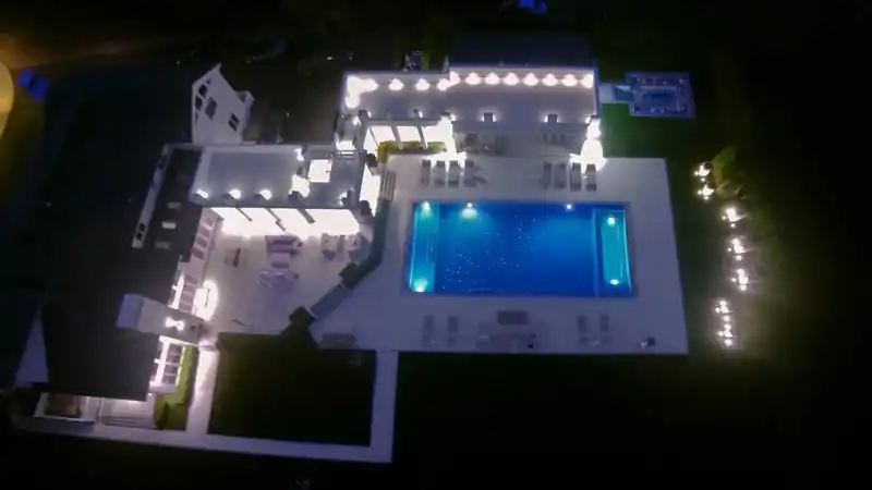 Aerial view of a house and its lit pool at night